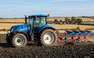 Trator New Holland T7.205 AutoCommand azul com implemento de aração